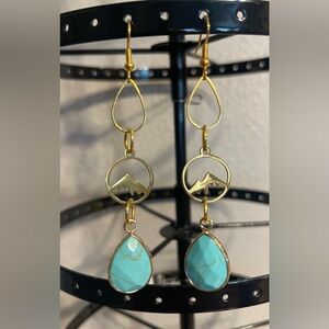 Handcrafted earrings with gold colored mountain charm and turquoise stones.